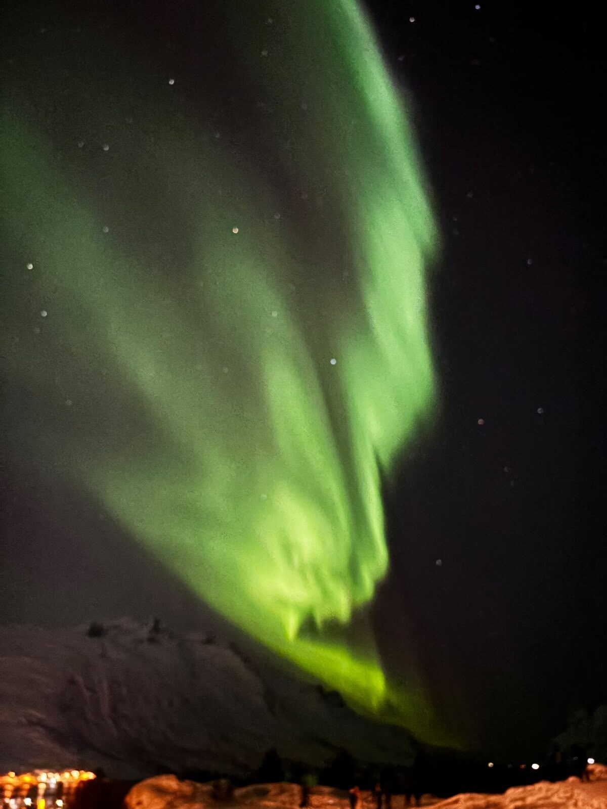 Bright green aurora over snowy mountains